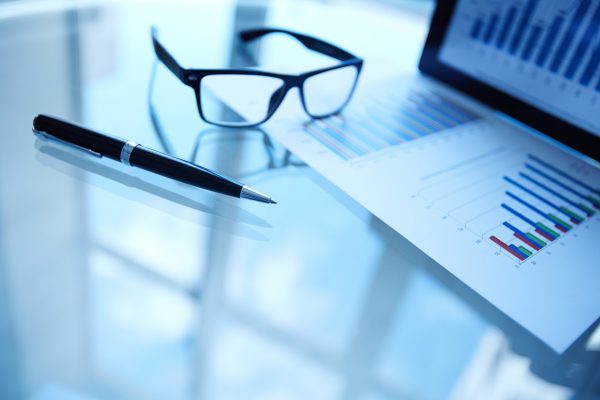Business objects on workplace Image of paper, eyeglasses, pen and electronic data in touchpad on workplace